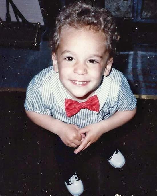 Peter as a child, in a striped shirt and a red bow tie